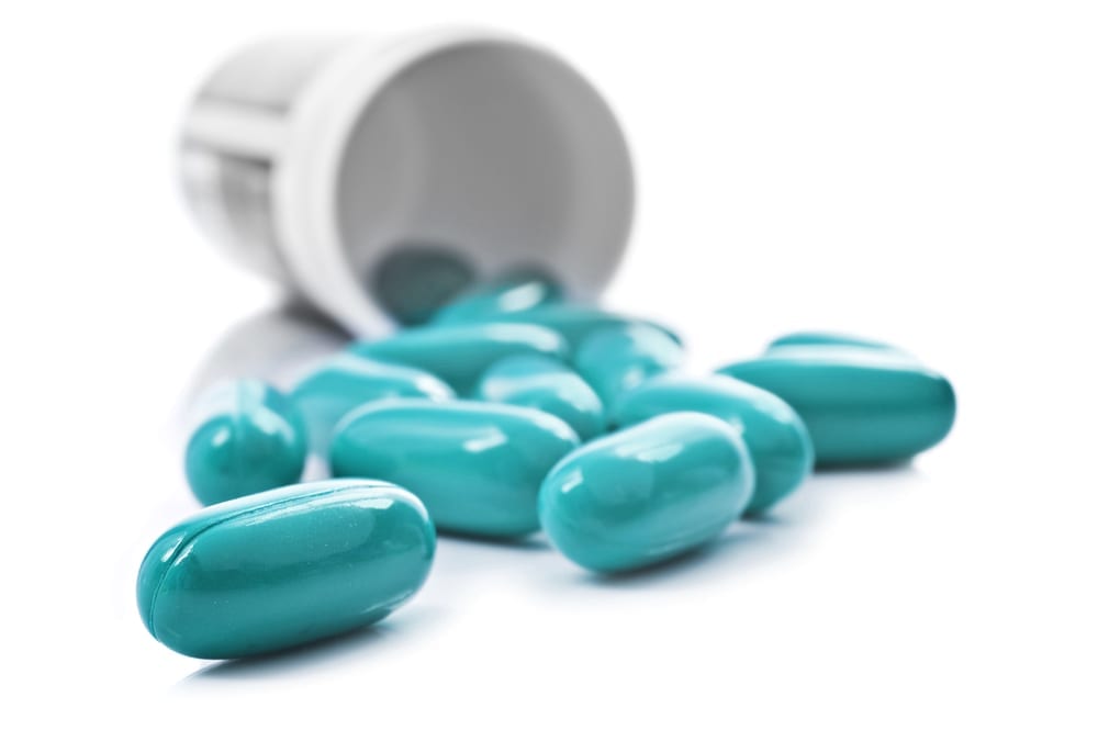 [blue capsules spilling out of a bottle]